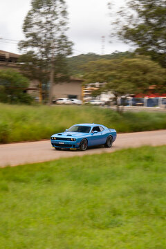 Blue Dodge Challenger driving fast on city freeway, High performance muscle car in movement on road