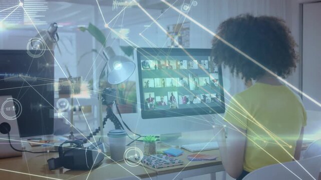 Woman sitting at desk scrolling grid, activating network HUD and reviewing content for design