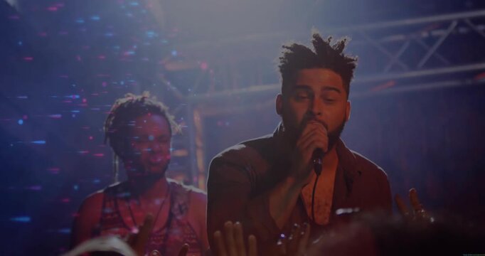 Song starting, singer holding mic, singing and gesturing, engaging crowd, bandmate bobbing, lights