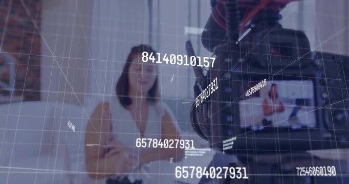 Vertical video: Woman sitting at table while camera moving in, starting tech data-grid demo overlay