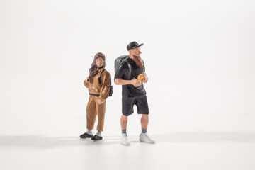 Naklejka premium Miniature travelers standing together with outdoor gear