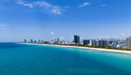 Obraz premium Miami beach with turquoise waters. Aerial view of sandy coastline and waves. Tropical Miami Beach scene with sandy beach.