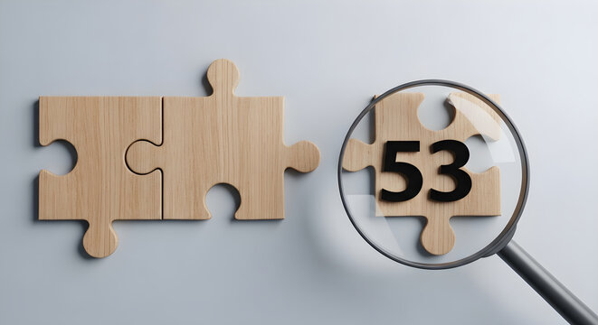 A magnifying glass examines a jigsaw puzzle piece with the number 53 on a gray surface with wooden puzzle pieces.