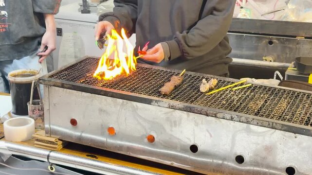 Chef Grilling Yakitori Meat Skewers Over Open Flame in Ueno Tokyo