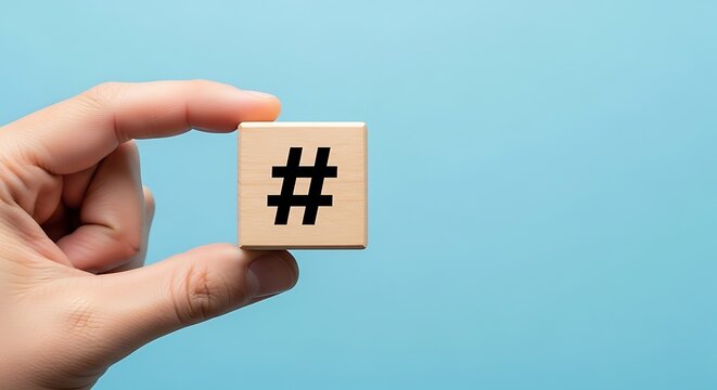 Hand holding wooden cube with hashtag symbol on blue background