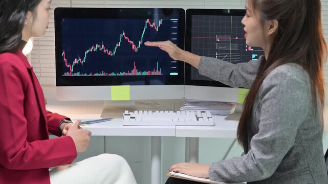 Successful businesswomen shaking hands after stock market analysis