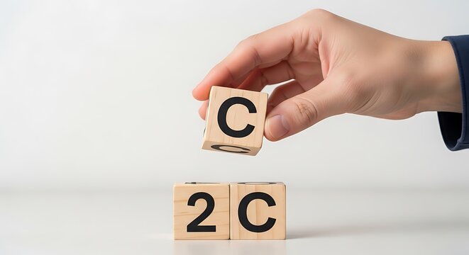 Hand Holding Wooden Cube with Letter C Above Two Cubes with 2 C
