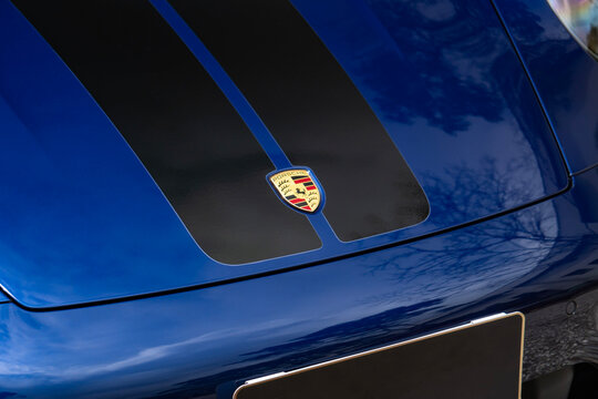 Blue Porsche 911 Carrera hood black stripes and automaker emblem, Luxury sports car front end badge close up details