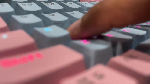 Finger typing on backlit mechanical keyboard in close up, creating dynamic, modern, and tech-focused atmosphere.