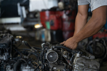 Obraz premium Close up of mechanic hands repairing a car engine in an auto garage workshop service center