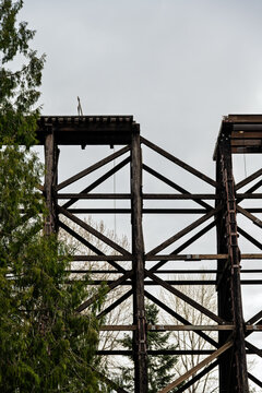 Old Wilburton wooden railway trestle bridge, out of service, with train tracks and section of bridge missing, deathtrap safety hazard, mind the gap
