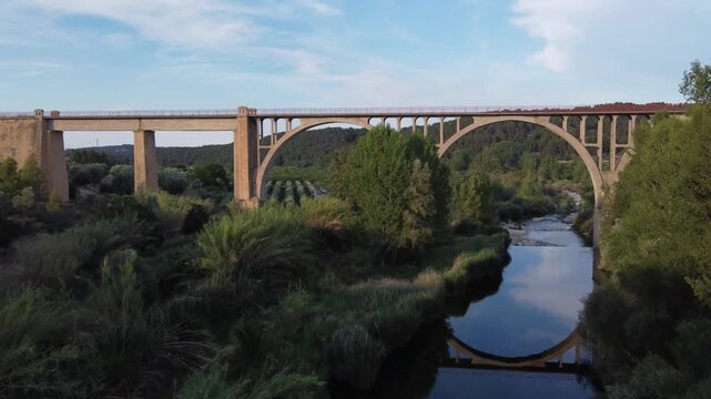 Aerial reveal of a river and a railway viaduct converted into a greenway. Matarra&ntilde;a river, Spain.
