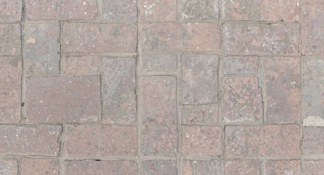 Worn stone textured stamped concrete pavers in red and white squares forming outdoor pavement