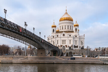 Fototapeta premium Cathedral of Christ the Savior and the Patriarchal Bridge from the Beresnevskaya embankment of the Moskva River on a sunny winter day, Moscow, Russia
