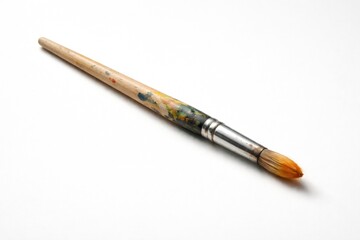 Naklejka premium paintbrush resting on a plain white backdrop with soft shadows