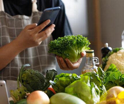 Middle Aged Asian Man Checking Nutrition Information While Choosing Vegetables
