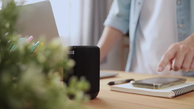 Track Shot Smart Speaker Virtual Assistant or Artificial Intelligence Concept by Standing Man Connecting Smart Phone with Smart Speaker