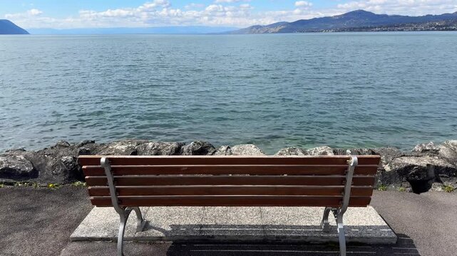 Pull back from bench by Lake Geneva peaceful landscape scene