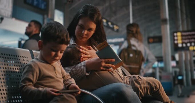 Patient Mother Feeds Infant Naturally, Waiting For Flight at International Airport. Inclusive Public Spaces, Healthy Infant Nutrition, Emotional Bond Between Mother and Child During Family Travel.