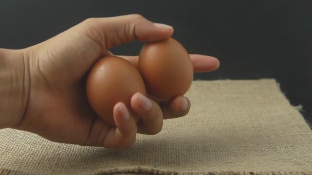 Rustic still-life photograph featuring fresh brown chicken eggs resting on a textured burlap (hessian) cloth. The composition emphasizes a "farm-to-table" aesthetic with its natural tones and organic 