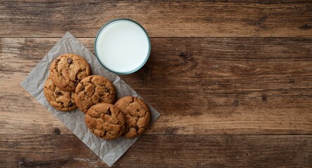 Fototapeta premium Top angle shot of cookies and a milk glass on wooden plank surface