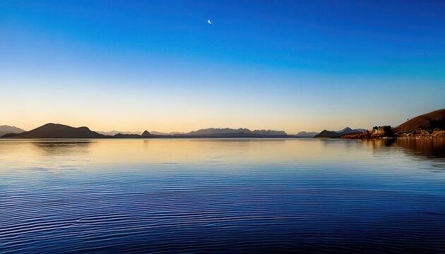 Vista panor&acirc;mica de um lago tranquilo ao entardecer com montanhas distantes sob um c&eacute;u azul profundo e o brilho suave da lua crescente no horizonte.