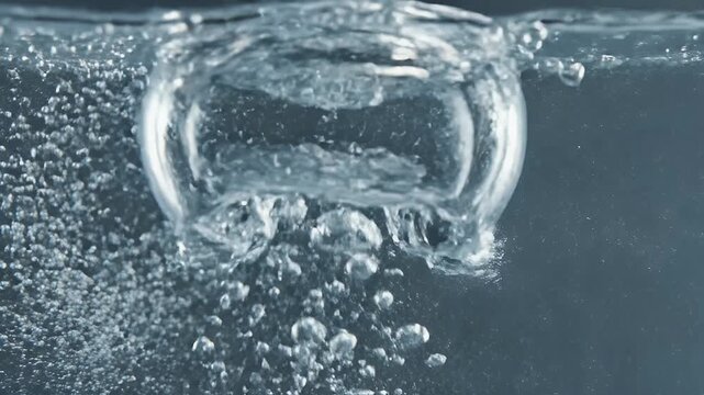 Macro shot of bubbly water creating a large air pocket with small spheres rising upwards