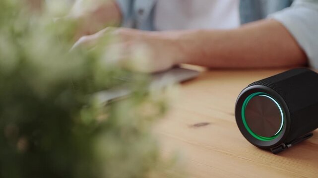 Track Shot Smart Speaker Virtual Assistant or Artificial Intelligence Concept by Man Typing Laptop Computer with Smart Speaker