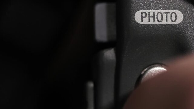 Close up of photo button pressed on dark grey device with wide copy space on left