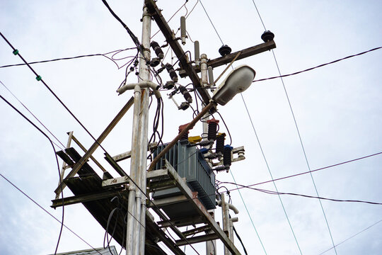 Overhead electrical transformer on utility pole, trafo dengan kabel listrik yang tidak rapi