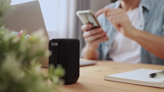 Track Shot Smart Speaker Virtual Assistant or Artificial Intelligence Concept by Man Connecting Smart Phone with Smart Speaker