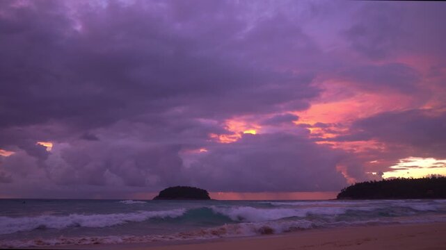 smooth waves hit on the beach at puple sunset.
purple clouds cover the ocean during colorful cloud in sunset at Kata beach Phuket.
video 4K. Scene of pink light in the sky background.