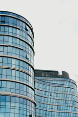 Fototapeta premium Modern buildings with glass facades in a city at midday on a clear sky