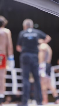 A boxing match is in progress with a referee and two fighters