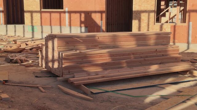Static shot of bundled wood boards on dusty construction jobsite