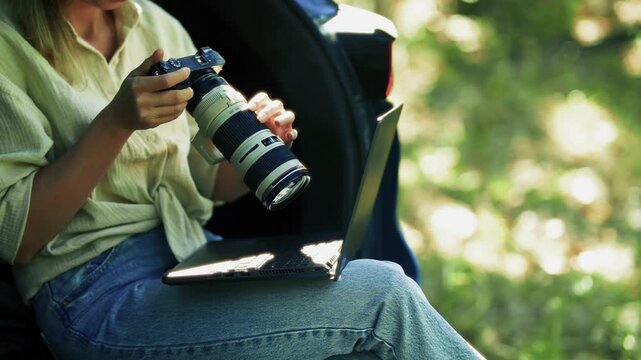 Photographer Reviewing Images. Content Creator Working  Sitting In Car Trunk