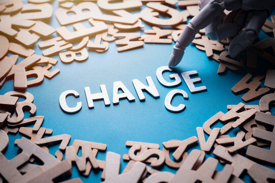 Robot hand changing the word Change to Chance on a blue background