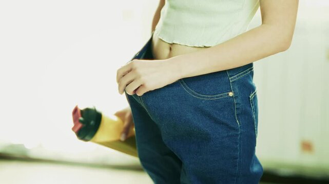 Woman Showing Weight Loss Progress Holding. Successful Diet Result And Body Transformation