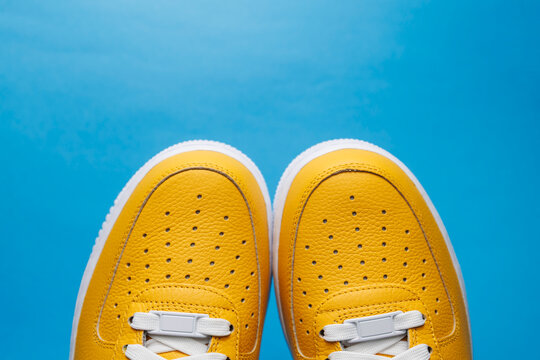 Paire de baskets jaunes sur fond bleu uni avec espace pour texte