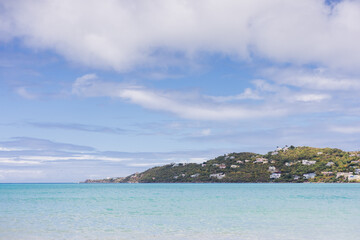 Naklejka premium Cloudy sky over calm Caribbean water with island coastline