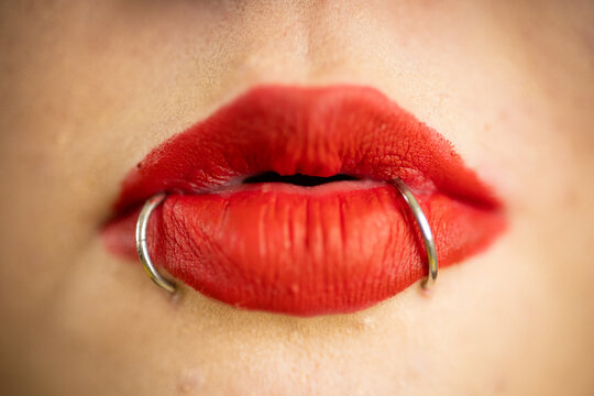 Red lips with body piercings expressing alternative style