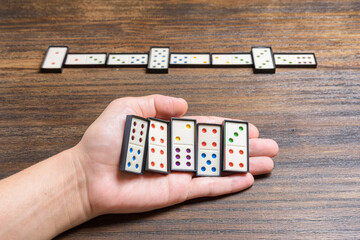 Playing dominoes at a wooden table for fun activity