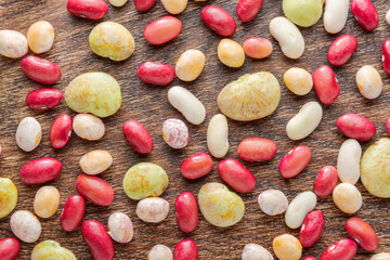 Colorful beans of different varieties and sizes on wooden table