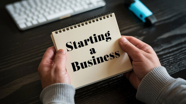 Hands Holding Notepad with Starting a Business Text for Entrepreneurship and New Venture Planning Images