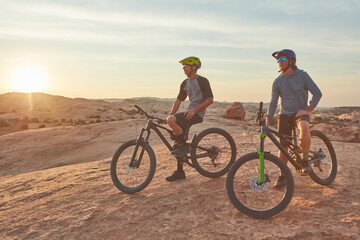 Fototapeta premium Exercise, sports and people mountain biking on trail outdoor for adventure, workout or fitness. Bicycle, sunset and athletes cycling in nature for cardio training with view by blue sky with space.