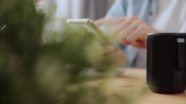Track Shot Right Frame Smart Speaker Virtual Assistant or Artificial Intelligence Concept by Man Connecting Smart Phone with Smart Speaker