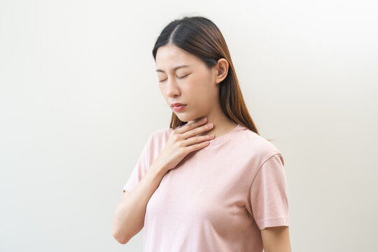 Sick, hurt asian young woman sore throat pain, have a fever, flu check self touching massage neck, face painful and infection isolated on background. Healthcare medical of influenza virus seasonal.