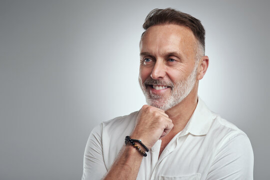 Think, journalism and man with smile in studio, planning feature article angle and news reporting career. Brainstorming, space and mature writer with idea for story, reflection and white background