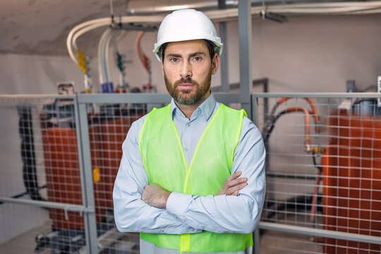 Portrait of Young Professional Heavy Industry Engineer or Worker Wearing Safety Vest and Hardhat