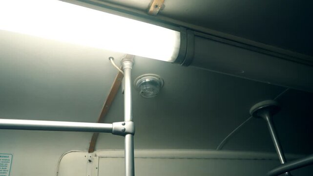 Light fixture and ceiling detail in a public transport vehicle during the day